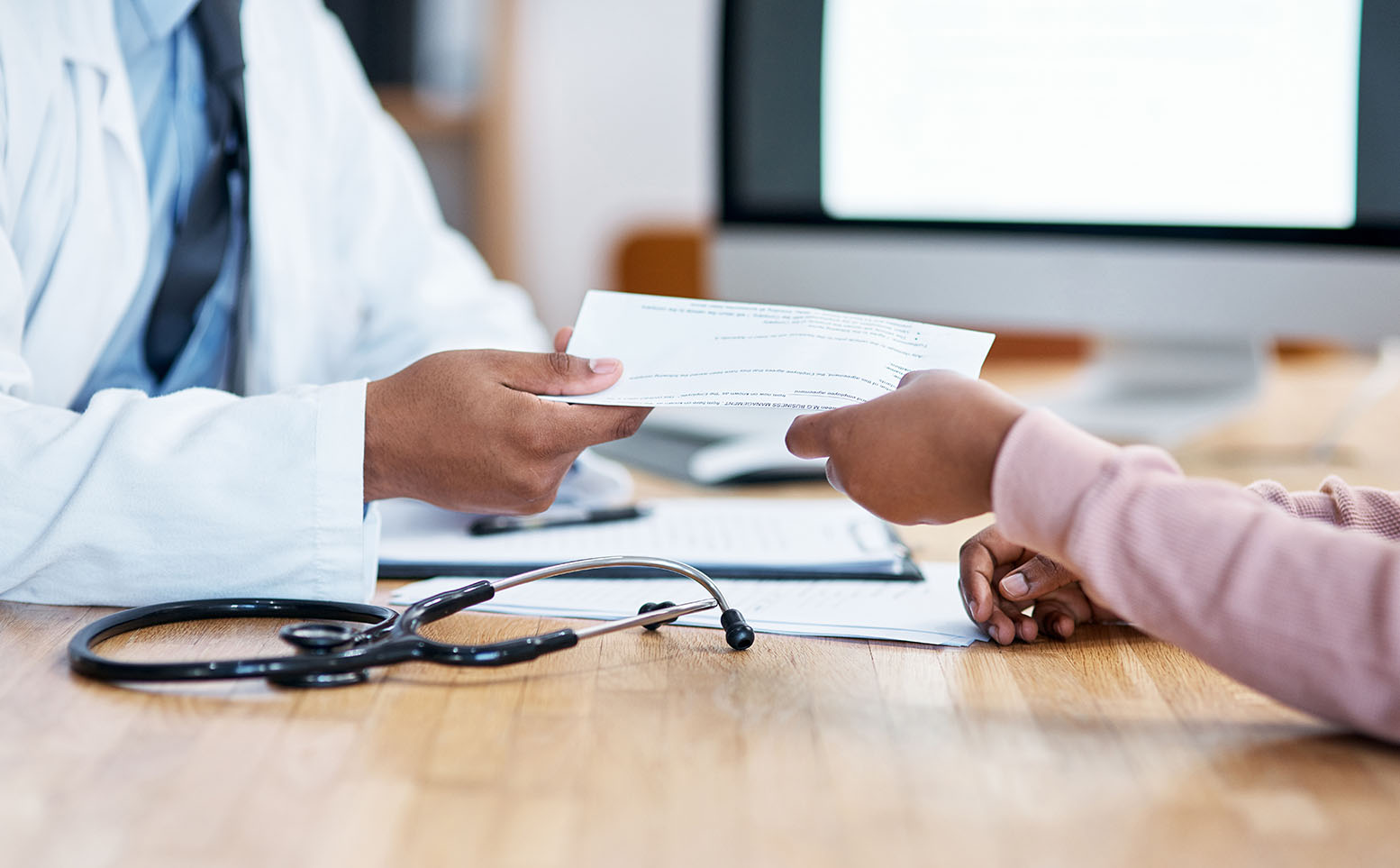 Closeup shot of an unrecognisable doctor giving paperwork to a patient during a consultation