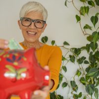 Senior woman holding her piggy bank